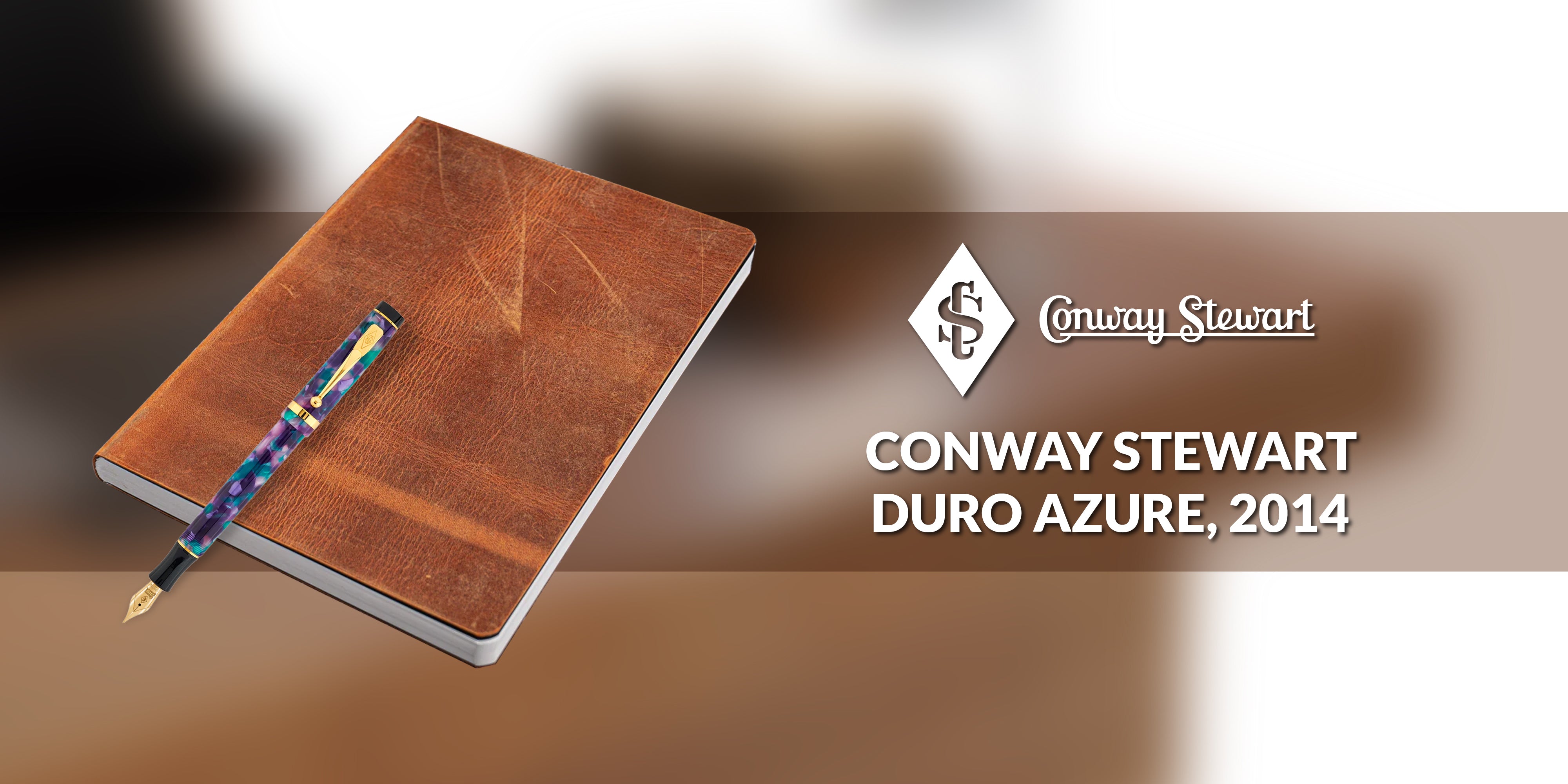 Banner for the Duro Azure pen, a blue and gold marbled fountain pen resting on a brown leather notebook
