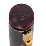 Gros plan du sommet de capuchon gravé d'un monogramme cursif sur le stylo-plume Lady Churchill Burgundy Pearl