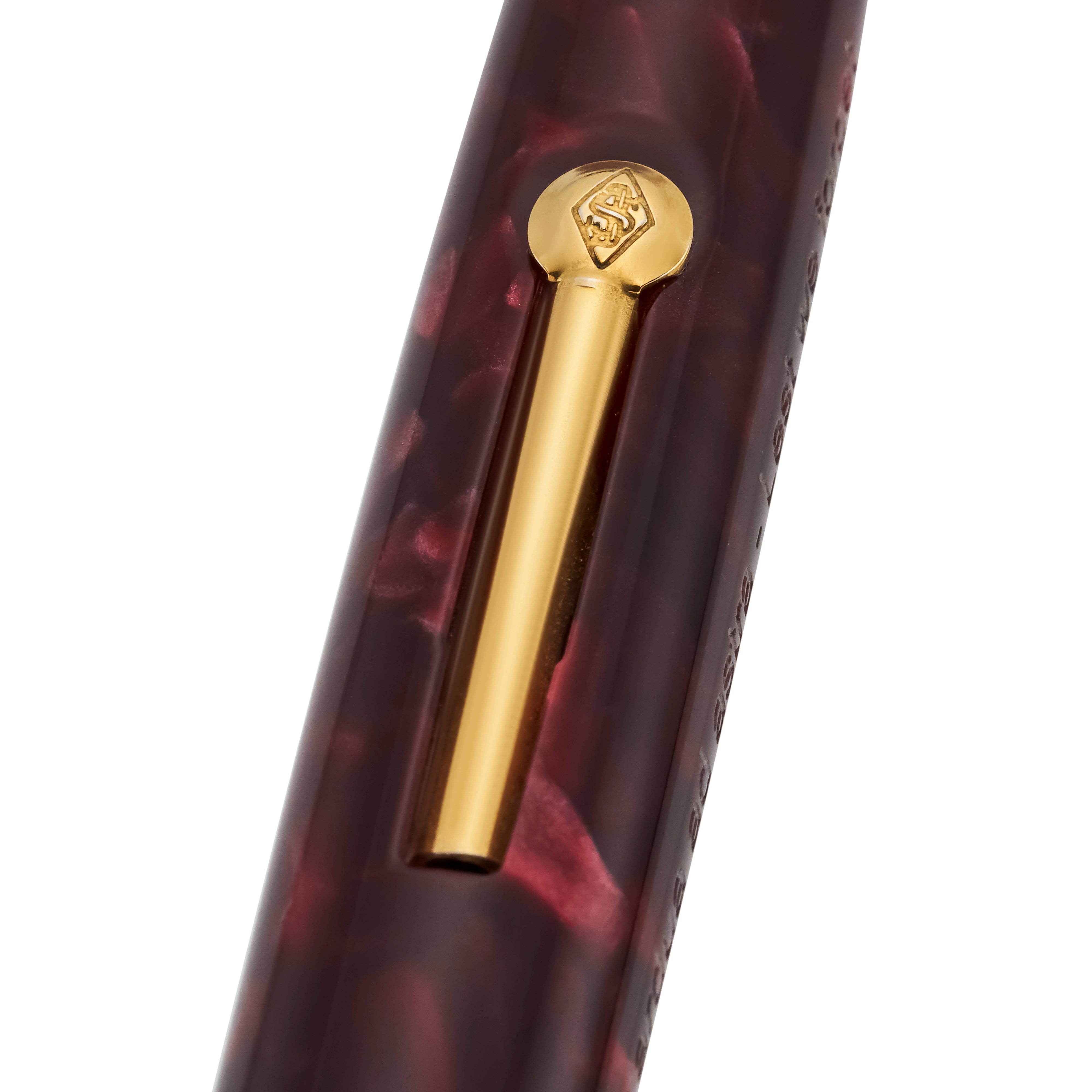 Close-up of the gold pocket clip and engraved finial on the burgundy marbled cap