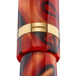 Nahaufnahme des mit einer Punze gestempelten goldenen Kappenrings des Collectors Pen Black Whirl, rot-schwarz gewirbeltes Acryl