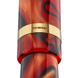 Nahaufnahme des mit einer Punze gestempelten goldenen Kappenrings des Collectors Pen Black Whirl, rot-schwarz gewirbeltes Acryl