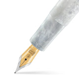 Primer plano del plumín en la pluma Raleigh White Crystal, plumín dorado y cuerpo jaspeado blanco