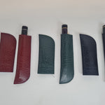 Drei erweiterbare Leder-Stiftetuis in Bordeauxrot, Grün und Marineblau, jeweils mit einem Stift