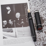 VE-Day pen beside a book page showing Churchill greeting crowds from a balcony on VE Day 1945