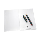 Recambio de cuaderno A5 abierto con una estilográfica jaspeada roja y verde sobre la contraportada de la marca Conway Stewart