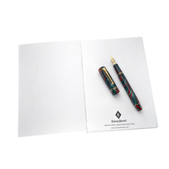 Open A5 notebook refill with a red and green marbled fountain pen resting on the Conway Stewart branded back page