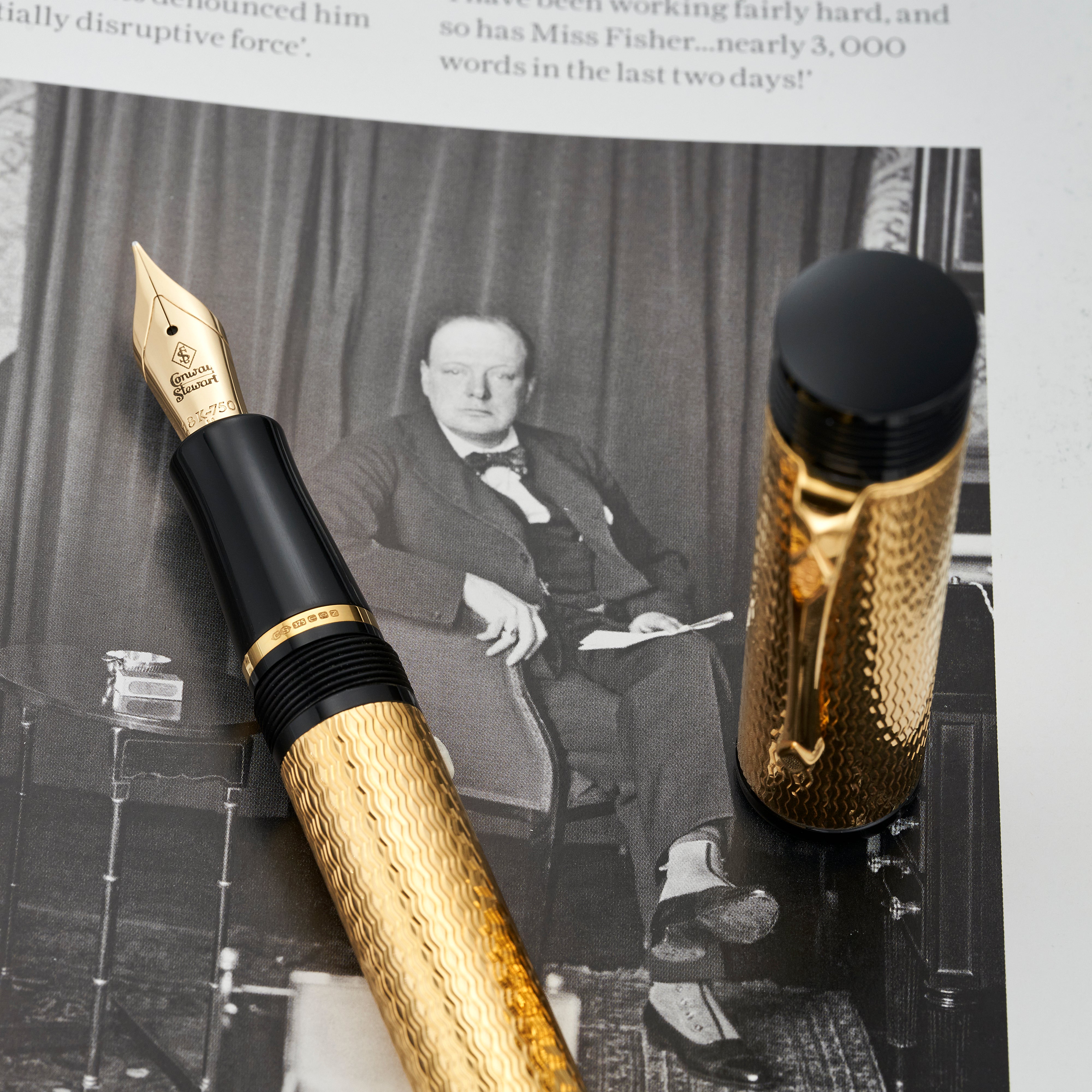 Conway Stewart Churchill Vermeil fountain pen nib and cap resting on a photograph of Churchill seated