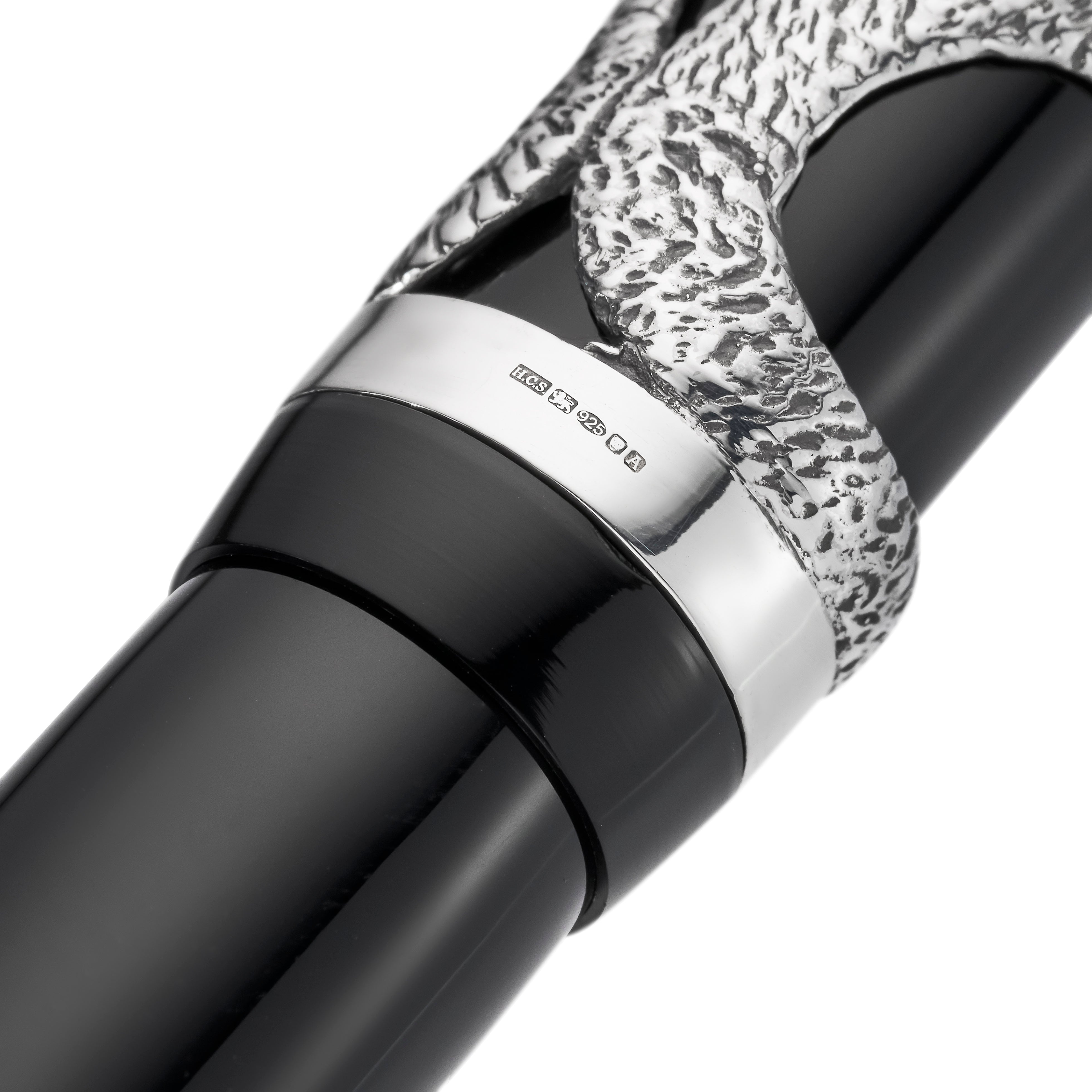 Macro of the cap band hallmarked HCS, 925, between the silver serpent design and black barrel