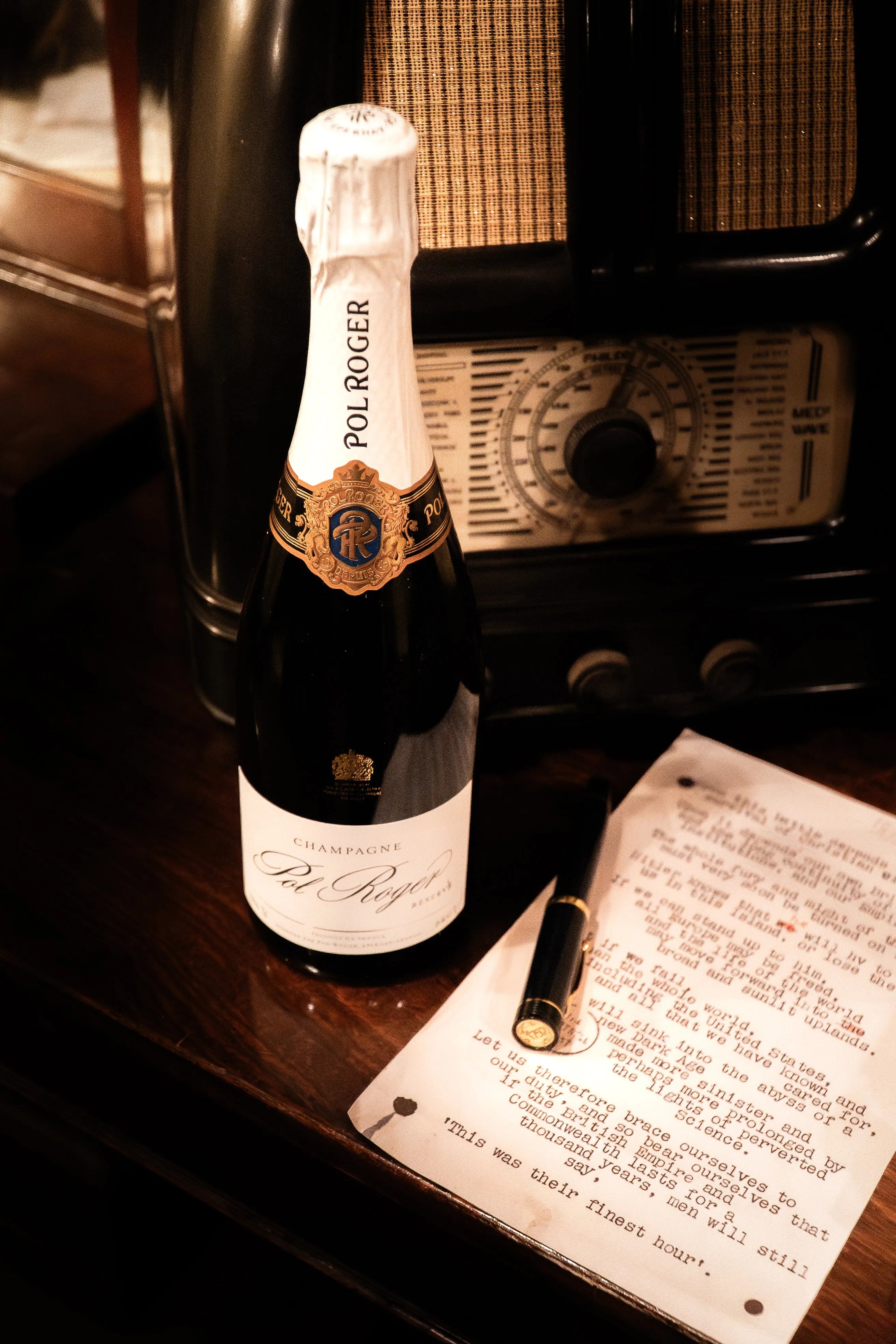 The Pol Roger 175th Anniversary fountain pen capped beside a Pol Roger champagne bottle and a typed Churchill speech