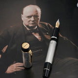 Füllfederhalter arrangiert auf einem sepiafarbenen Churchill-Porträt, gravierter Jubiläumsring auf der Kappe sichtbar