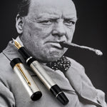 Stift und Kappe liegend auf einem Churchill-Foto, Feder und guillochierter Schaft im Vordergrund