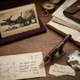 Burgundy marbled fountain pen displayed among WWII airman memorabilia and a handwritten flight log