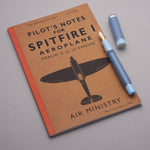 Conway Stewart Spitfire fountain pen resting on a vintage Pilot's Notes for Spitfire I Aeroplane booklet