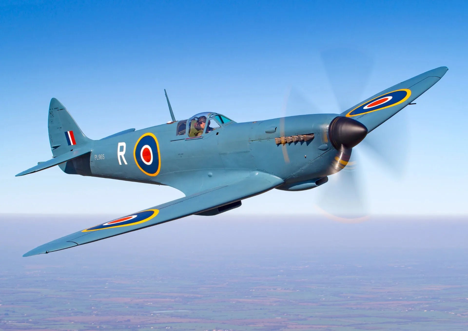 Avion de chasse Supermarine Spitfire en plein virage sur fond de ciel bleu