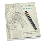 Ashmolean John Ruskin फाउंटेन पेन, An Instinct to Draw नामक पुस्तक पर रखा हुआ, जिसमें Ruskin के चित्र हैं