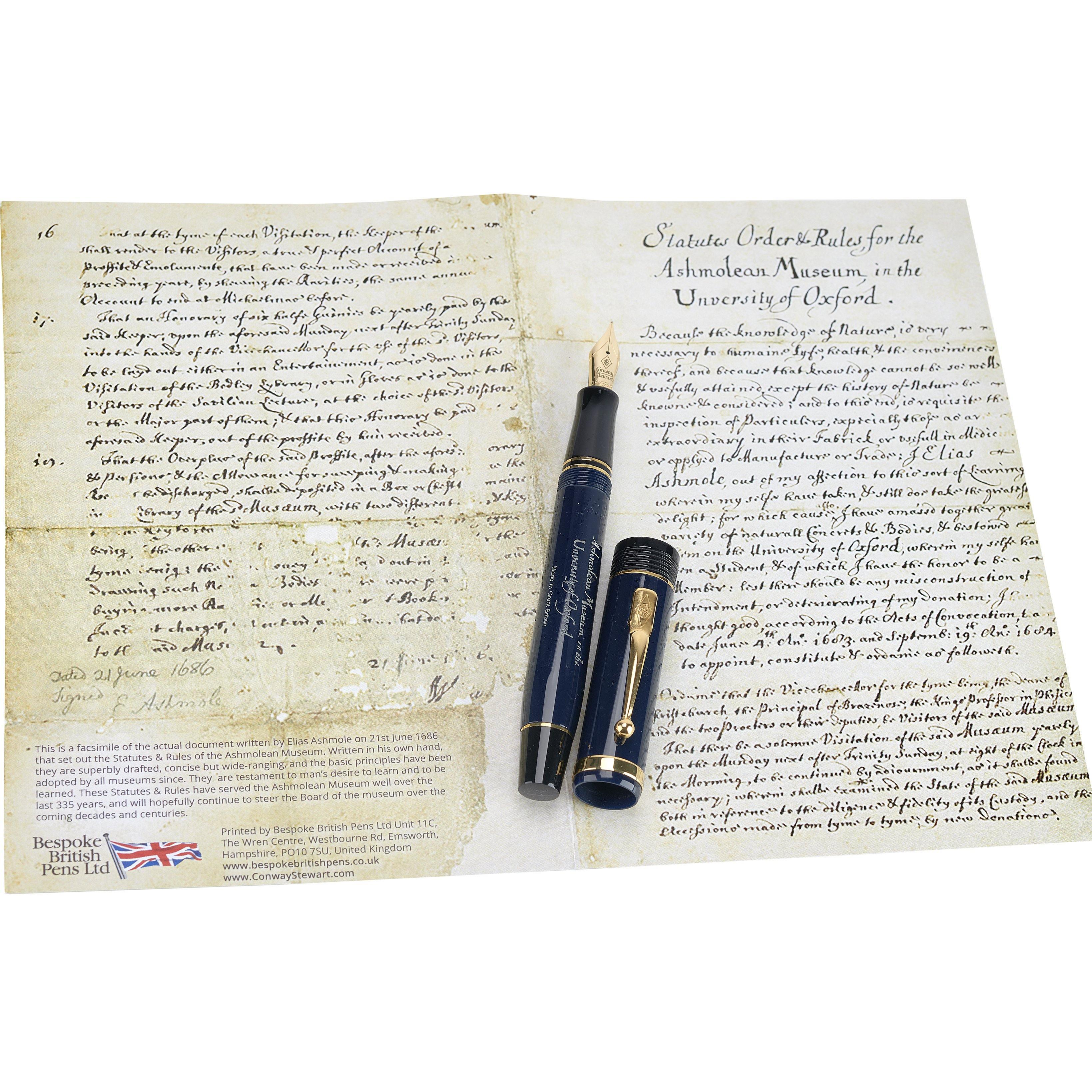 Ashmolean John Ruskin फाउंटेन पेन नेवी रंग में, कैप खोलकर, संग्रहालय के संस्थापक विधान की प्रतिकृति पर रखा हुआ
