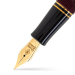 Close-up of the Churchill Bordeaux gold nib beneath the black cap and gold trim rings