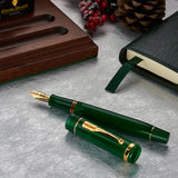Schaft und Kappe des Churchill Evergreen liegen getrennt auf einem Tisch neben einer Tintenflasche und festlicher Dekoration