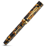 Churchill Honey Noire Lever-Fill pen fully capped, straight diagonal view of the mottled honey barrel and gold clip