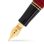 Makroaufnahme der goldenen Feder und des schwarzen Griffstücks des Churchill Red Stardust Füllfederhalters