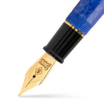 Series 100 Sapphire Blue निब का क्लोज़-अप, नीली मार्बल्ड एक्रिलिक सेक्शन के सामने गोल्ड-टोन निब