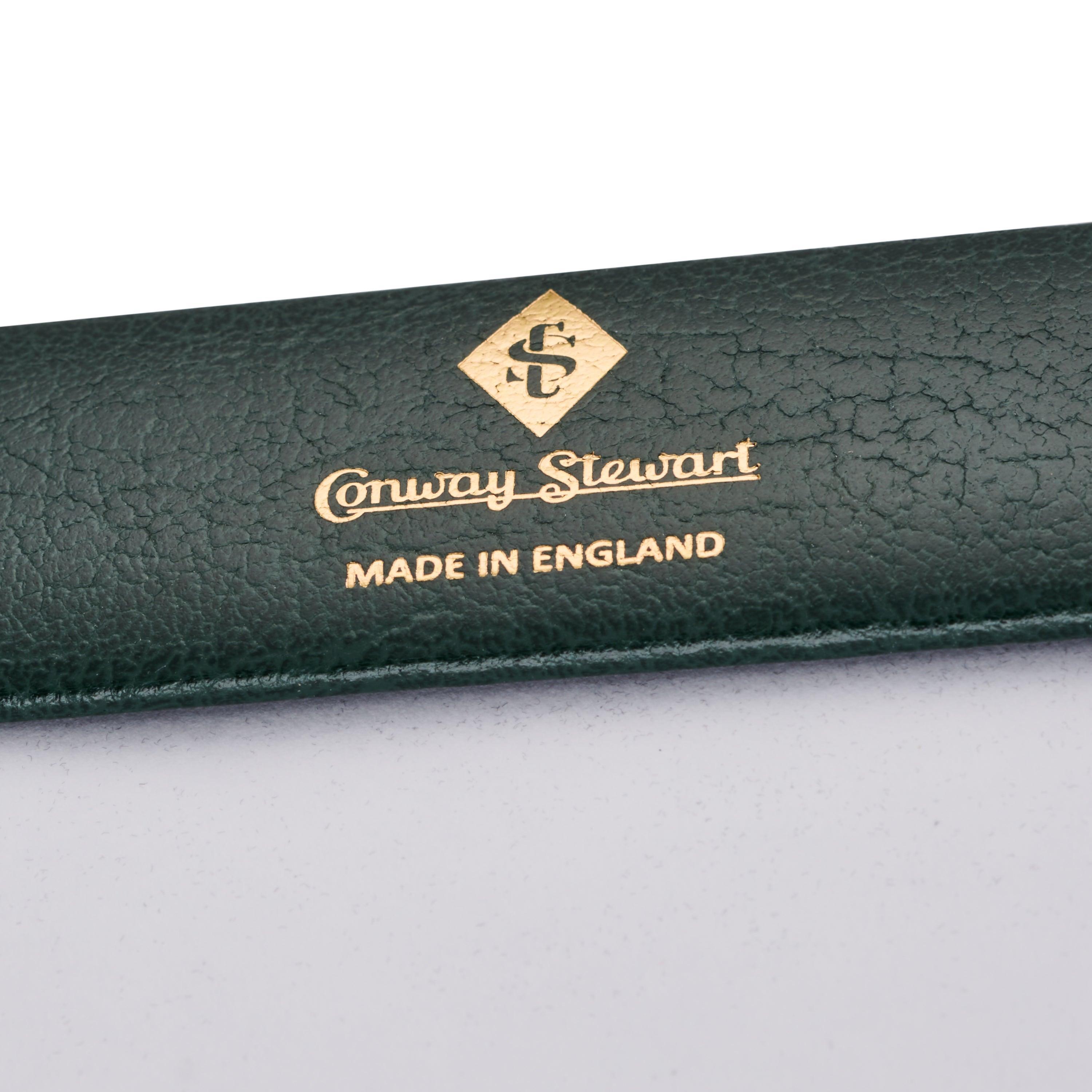 Primer plano del logotipo repujado en dorado Conway Stewart, Made in England, en la esquina del secante de escritorio
