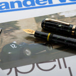 Vanwall pen and cap resting on racing memorabilia beside a vintage Vandervell magazine page