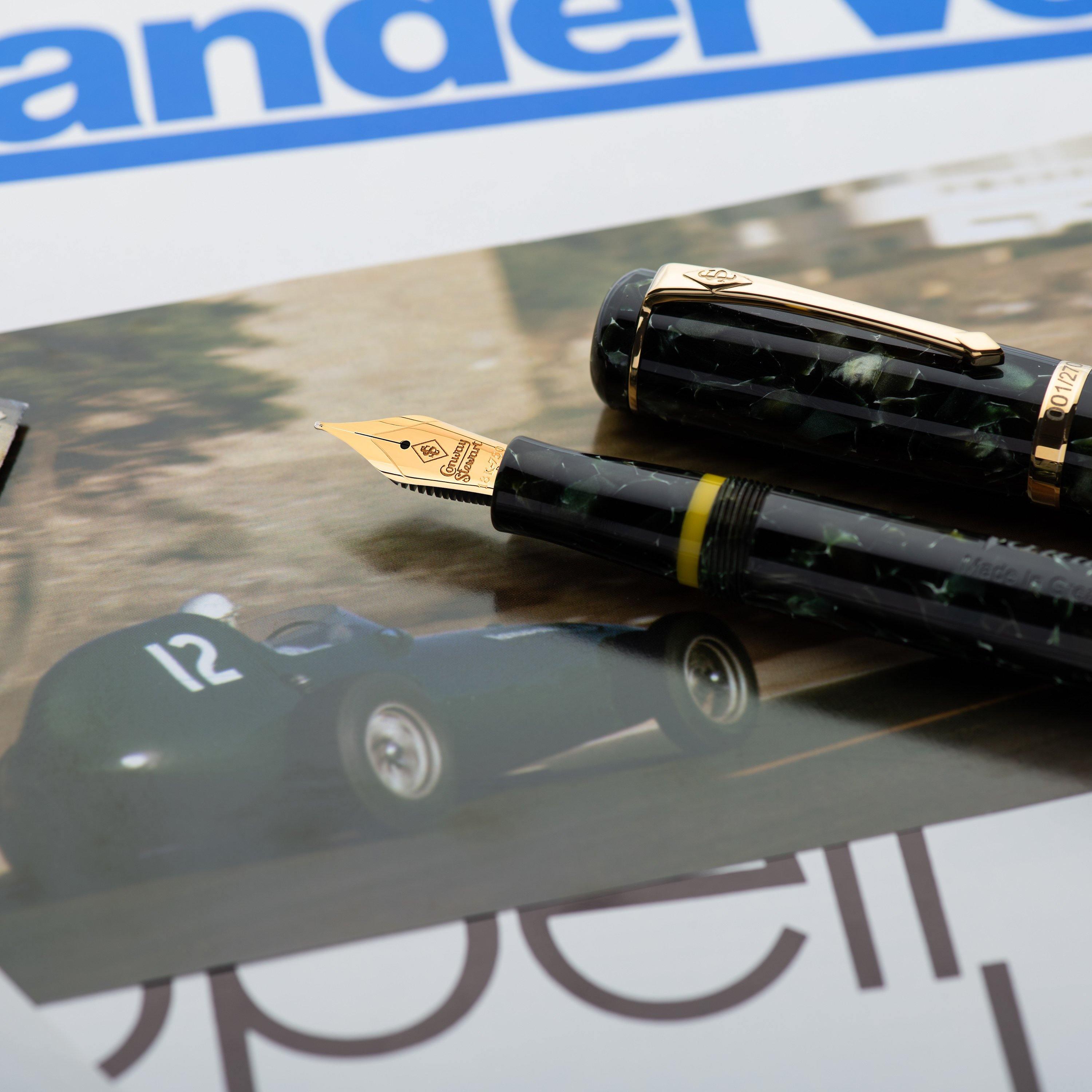 Vanwall pen and cap resting on racing memorabilia beside a vintage Vandervell magazine page