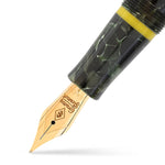 Close-up of the Vanwall fountain pen nib, gold with Conway Stewart engraving, above the yellow cap band