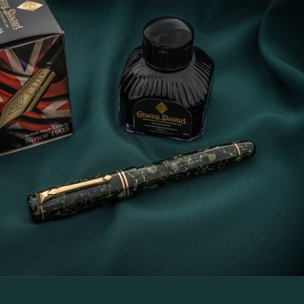 Winston Classic Green neben seiner Tintenflasche und der Geschenkbox mit Branding auf dunkelgrünem Stoff