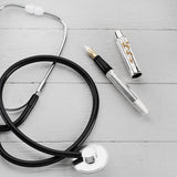 Doctor's Pen Füllfederhalter und Kappe liegen neben einem Stethoskop auf einer Holzoberfläche