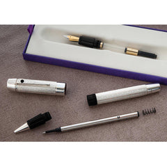 Rollerball conversion kit components laid out: cap, barrel, refill and spring, beside the original fountain pen in its box