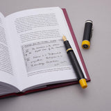 Alan Turing Pen resting on an open book page reproducing Turing's handwritten notes, cap standing beside it