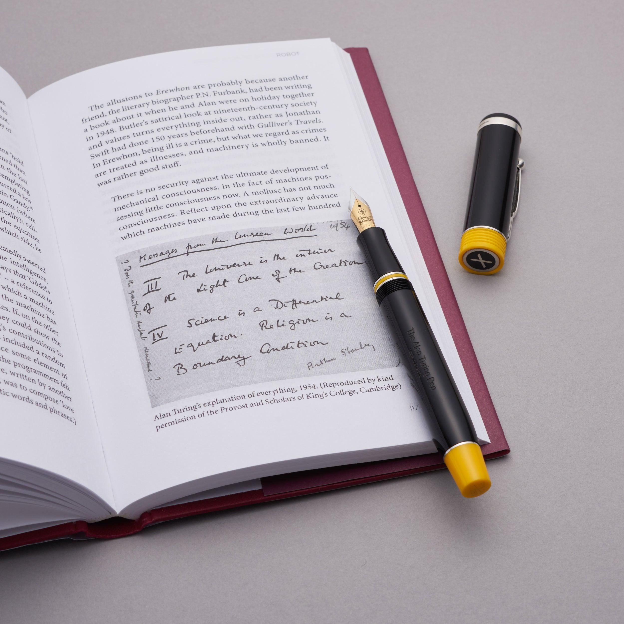 Alan Turing Pen resting on an open book page reproducing Turing's handwritten notes, cap standing beside it
