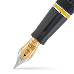 Macro view of the gold nib, silver cap band and yellow cap ring of the Alan Turing Pen