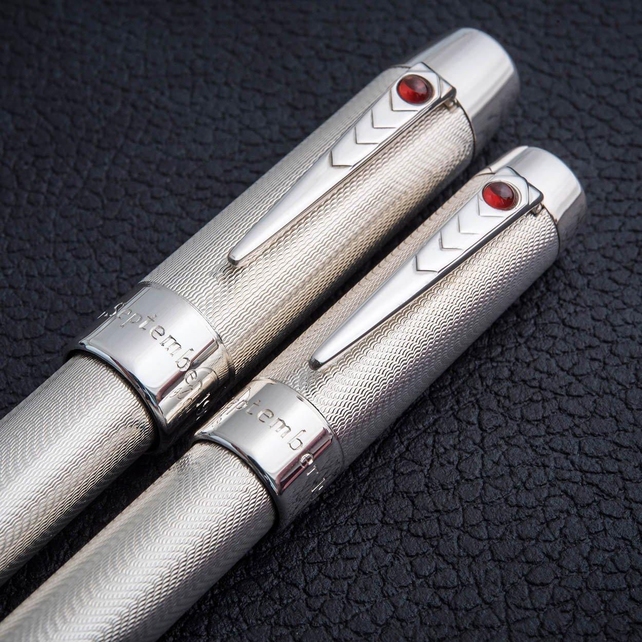 Paar Wedding Pens aus guillochiertem Sterlingsilber mit Rubin-Cabochon-Clips, zusammen liegend auf schwarzer Lederoberfläche